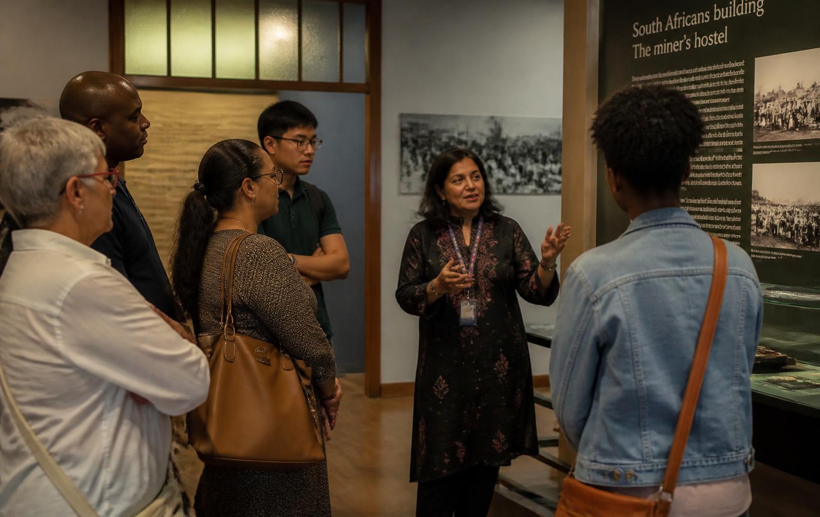 A museum guide interpreting a South African history exhibition for visitors in Johannesburg